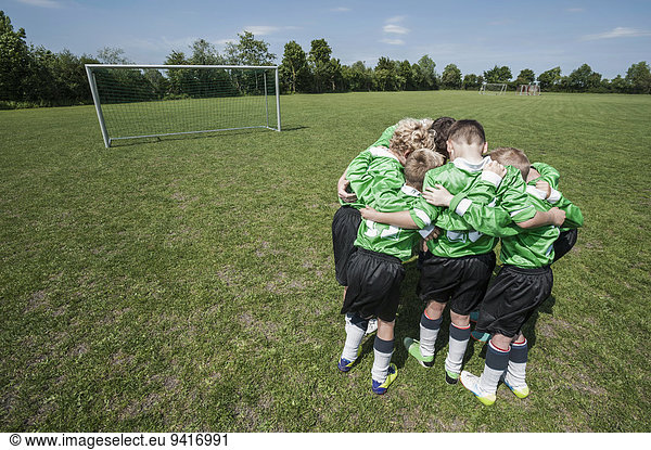 Junior soccer team in huddle circle from above