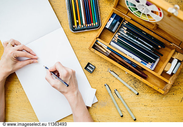 Künstler hält Bleistift  beginnt zu zeichnen  Draufsicht