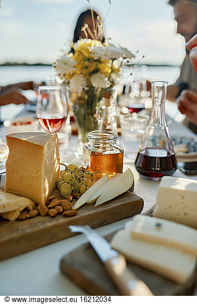 Käseplatte auf einem Tisch mit Menschen im Hintergrund