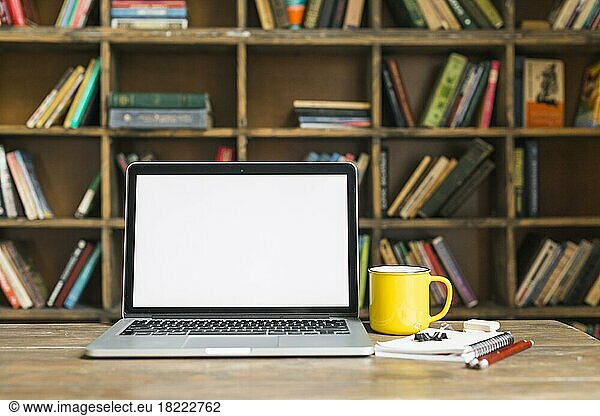 Kaffeebecher Laptop mit Schreibwaren Holzschreibtisch Bibliothek