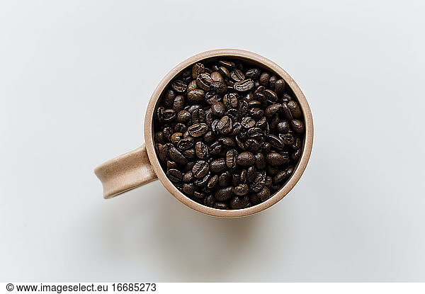 Kaffeetasse voll mit ganzen Kaffeebohnen