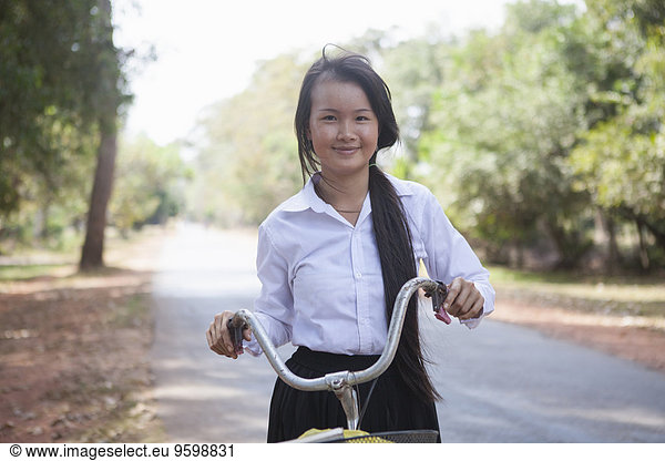 Kambodscha Mädchen mit ihrem Fahrrad auf der Landstraße  Siem Reap  Kambodscha