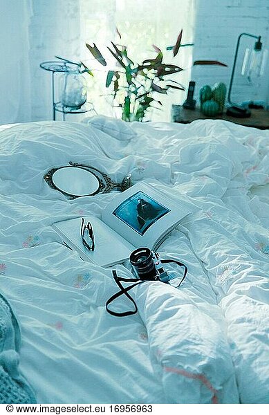 Kameraobjektiv Buchspiegel auf dem Bett