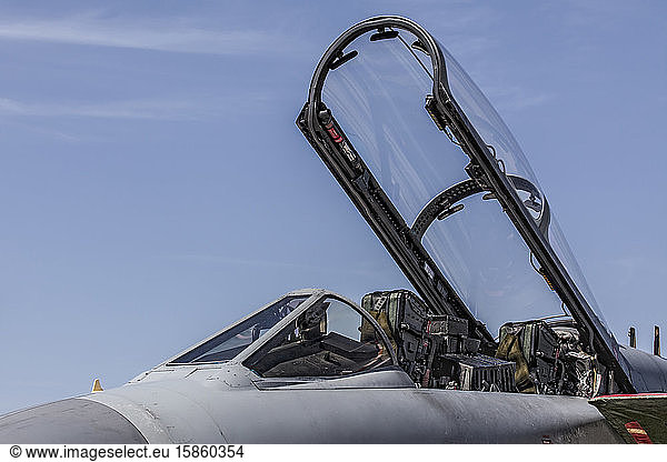 Kampfflugzeug mit offener Haube gegen blauen Himmel