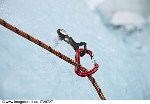 karabiner attached to ice screw on iceberg in the south of Iceland