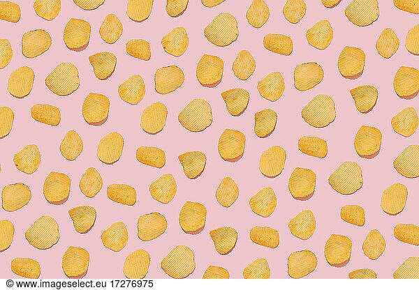 Kartoffelchips auf rosa Hintergrund