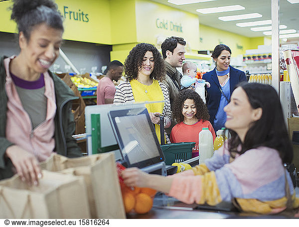 Kassiererin hilft Kunden an der Supermarktkasse
