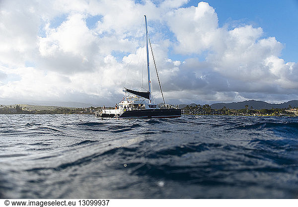 Katamaran segelt auf See gegen bewölkten Himmel