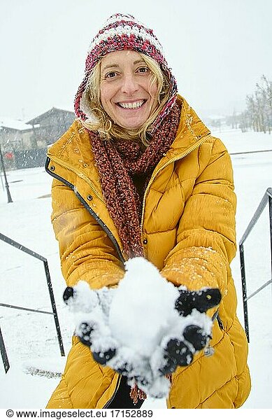 Kaukasische junge Frau macht einen Schneeball im Freien im Winter. Navarra  Spanien  Europa.