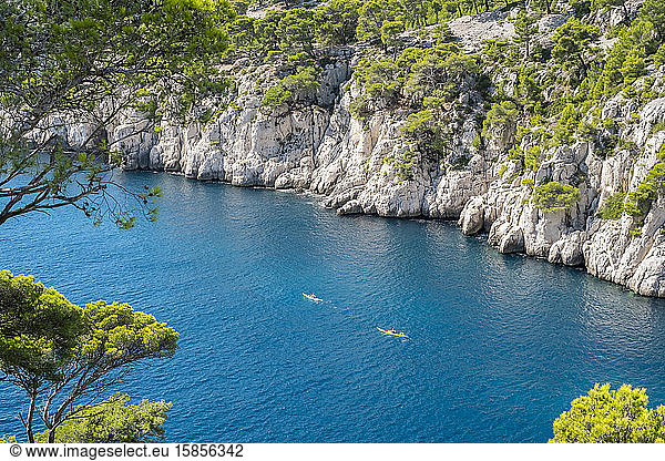 Kayakers paddling through blue water of Calanque de Port-Pin  France