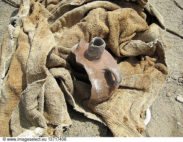 Keramikreste und einfarbige Textilien aus einer gestörten Bestattung  Peru. Nazca. 100 - 1400 n. Chr.  Mittlerer Horizont und Späte Zwischenzeit. Südperu.