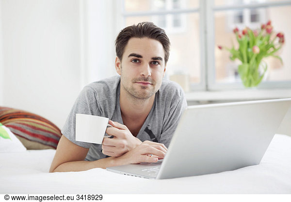 Kerl mit Computer und Kaffee