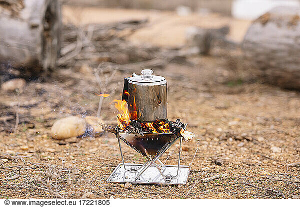 Kettle on camping stove at ground