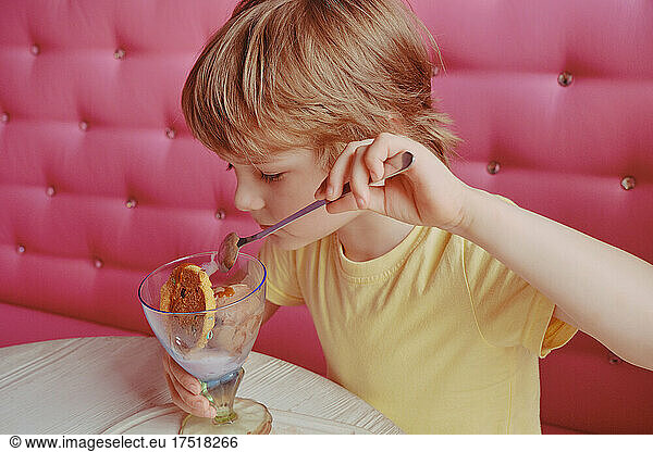 Kid enjoys ice-cream at the cafe