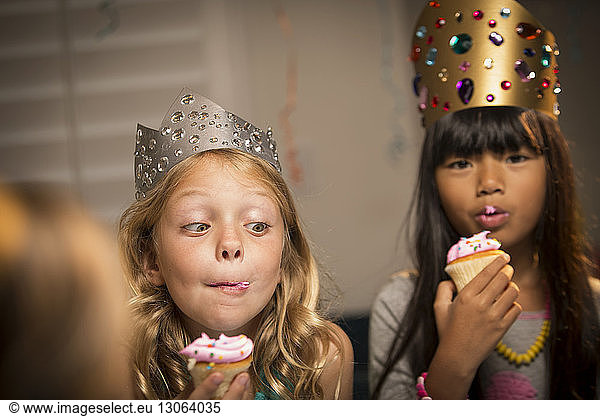 Kids eating cup cakes at birthday party