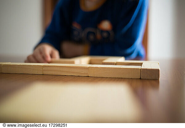 Kind spielt mit Holzgebäuden