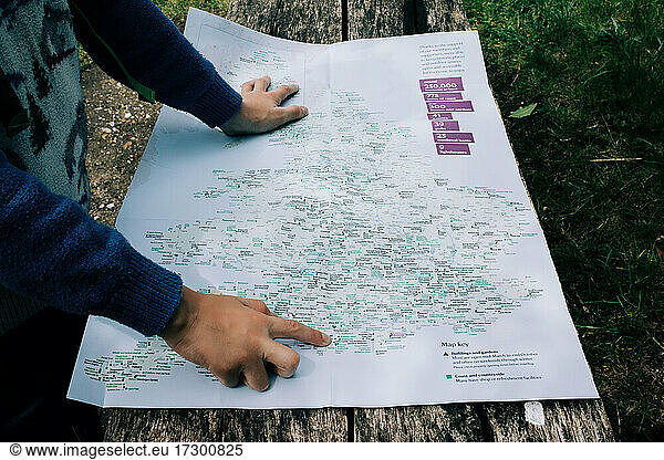 Kind zeigt auf eine Karte von England  während es im Freien auf Entdeckungsreise geht
