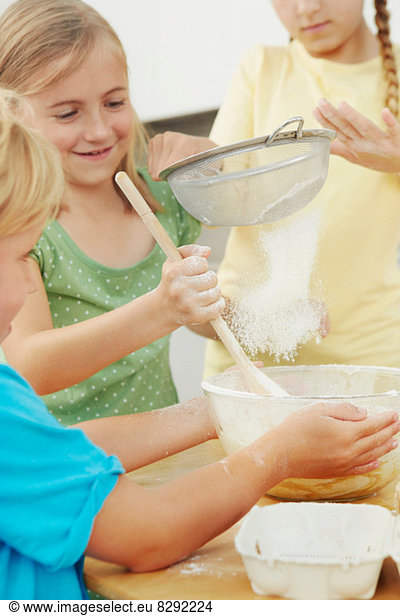 Kinder backen  Mehl in Rührschüssel sieben