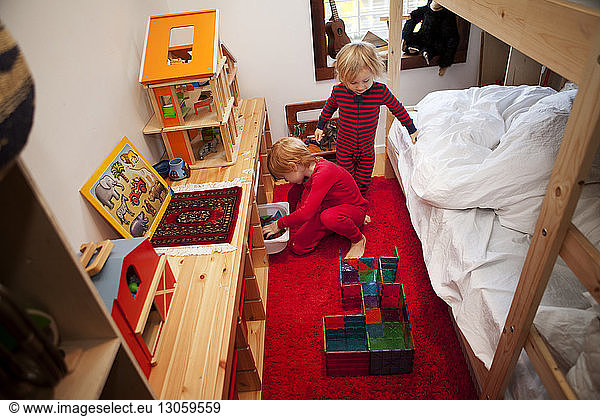 Kinder ordnen Spielzeug im Schlafzimmer an