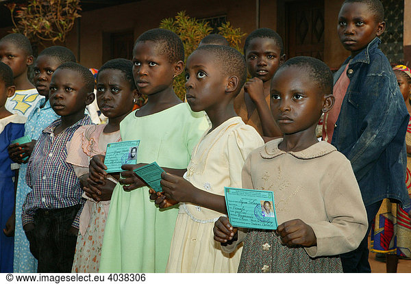 Kinder zeigen Schülerausweis vor  Berechtigung um Schulmaterial zu erhalten  Frauenbildungszentrum  Bamenda  Kamerun  Afrika