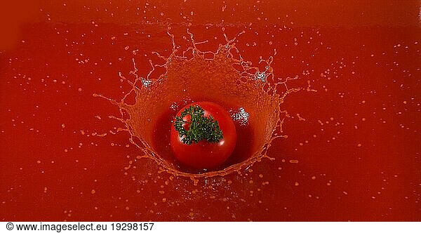 Kirschtomate (Solanum lycopersicum)  Früchte  die in den Saft der Tomate fallen