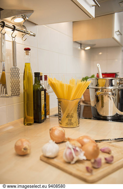 Kitchen counter with spaghetti  onion and garlic