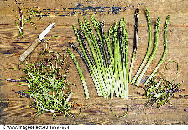 Kitchen knife and freshly peeled asparagus stalks