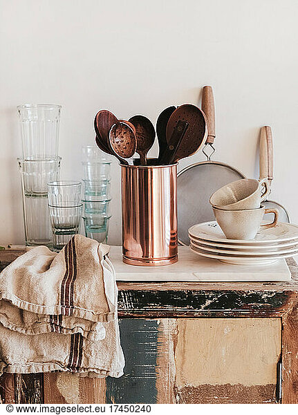 Kitchen utensils  glassware and dinnerware on rustic kitchen counter