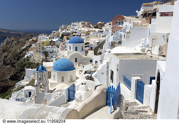 Klassischer Blick auf das Dorf Oia mit seinen blauen Kuppelkirchen und bunten Häusern  Oia  Santorin  Kykladen  Griechische Inseln  Griechenland  Europa