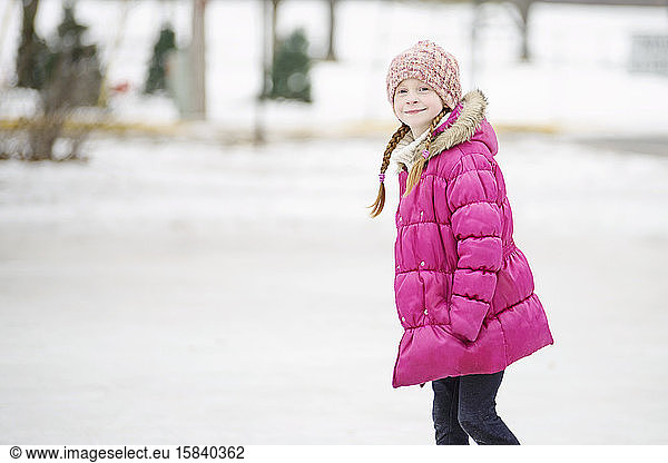 Kleine Mädchen laufen Schlittschuh im Freien