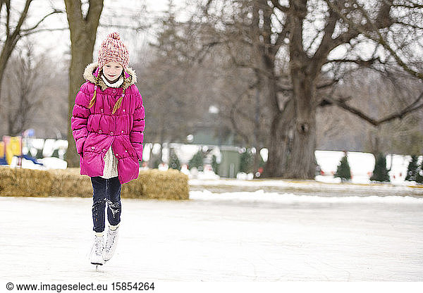 Kleine Mädchen laufen Schlittschuh im Freien