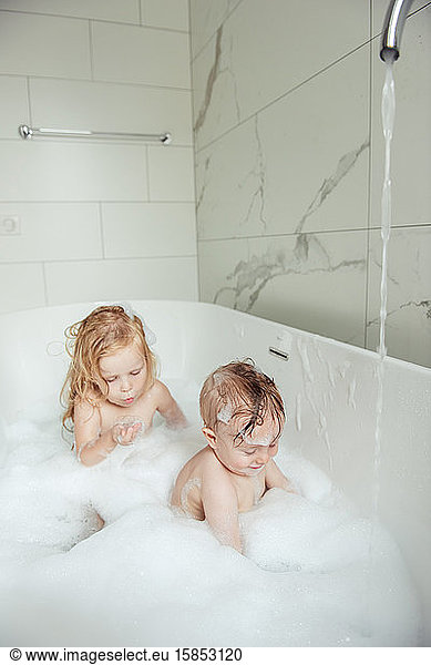 kleiner Bruder und kleine Schwester baden in einem Schaumbad
