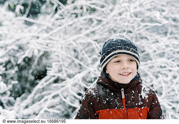 Kleiner Junge erlebt einen Schneefall im Oktober in Neuengland
