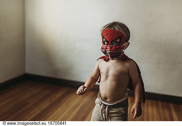 Kleiner Junge in Halloween-Kostüm und Gesichtsmaske