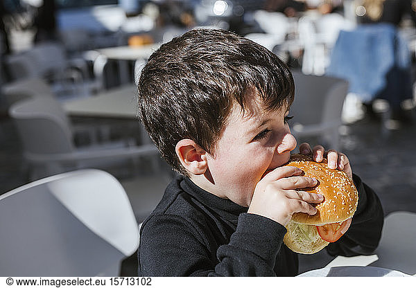 Kleiner Junge isst einen Hamburger