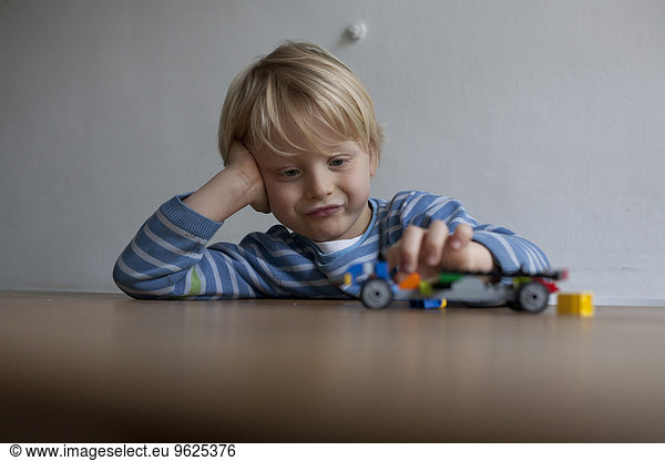 Kleiner Junge spielt mit Spielzeugauto