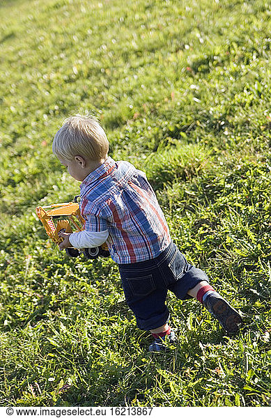 Kleiner Junge (2-3) spielt mit Spielzeugauto  Rückansicht