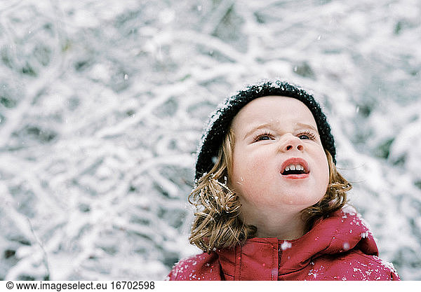 Kleines Mädchen erlebt einen Schneefall im Oktober in Neuengland