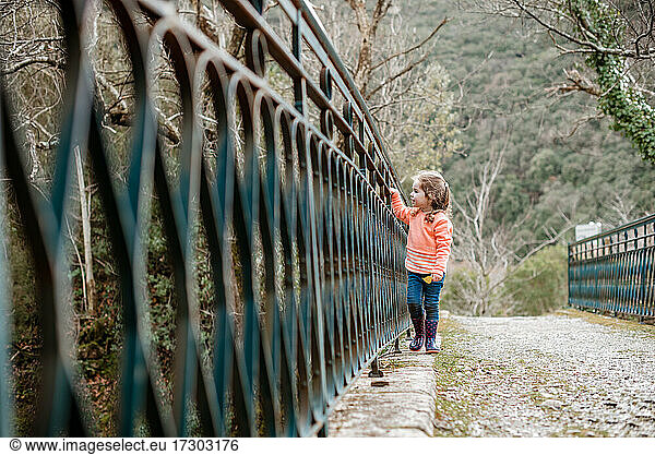 Kleines Mädchen geht entlang einer alten Metallbrücke in Frankreich