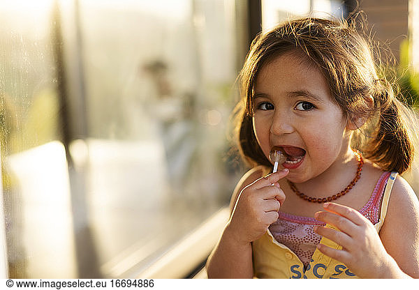 Kleines Mädchen isst einen Lutscher