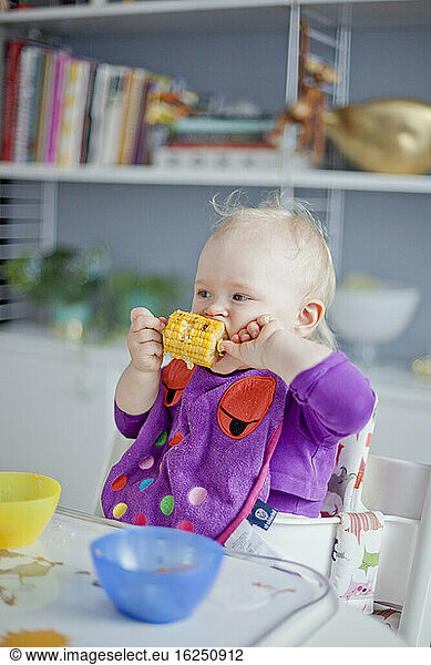 Kleines Mädchen isst Maiskolben