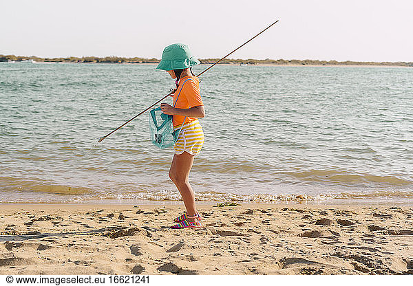Kleines Mädchen sammelt Plastikmüll vom Strand