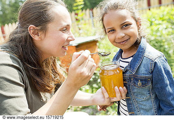 Kleines Mädchen schmeckt natürlichen Honig