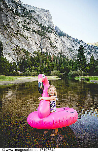 Kleines Mädchen umarmt Flamingo Floatie in Yosemite Umgebung