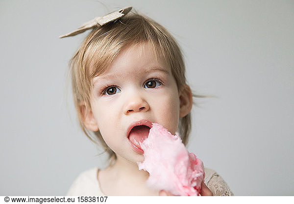 Kleinkind isst rosa Zuckerwatte