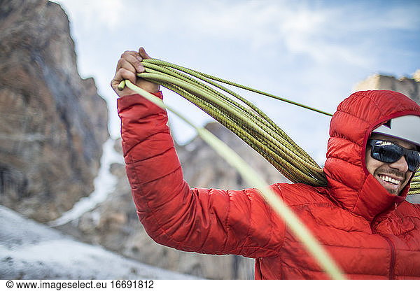 Kletterer wickelt Seil nach erfolgreicher Besteigung auf