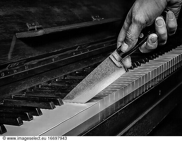 knife cutting a piano like a cake