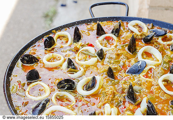 Kochen von typisch spanischer Meeresfrüchte-Paella am Herd