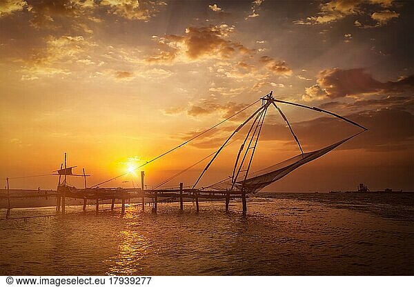 Kochi chinesische Fischnetze bei Sonnenuntergang. Fort Kochin  Kochi  Kerala  Indien. Mit Streulicht und Linsenreflexion