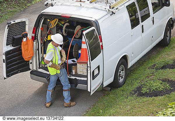 Kommunikationsarbeiter bereitet sich darauf vor  den Mast an seinem Lastwagen zu erklimmen